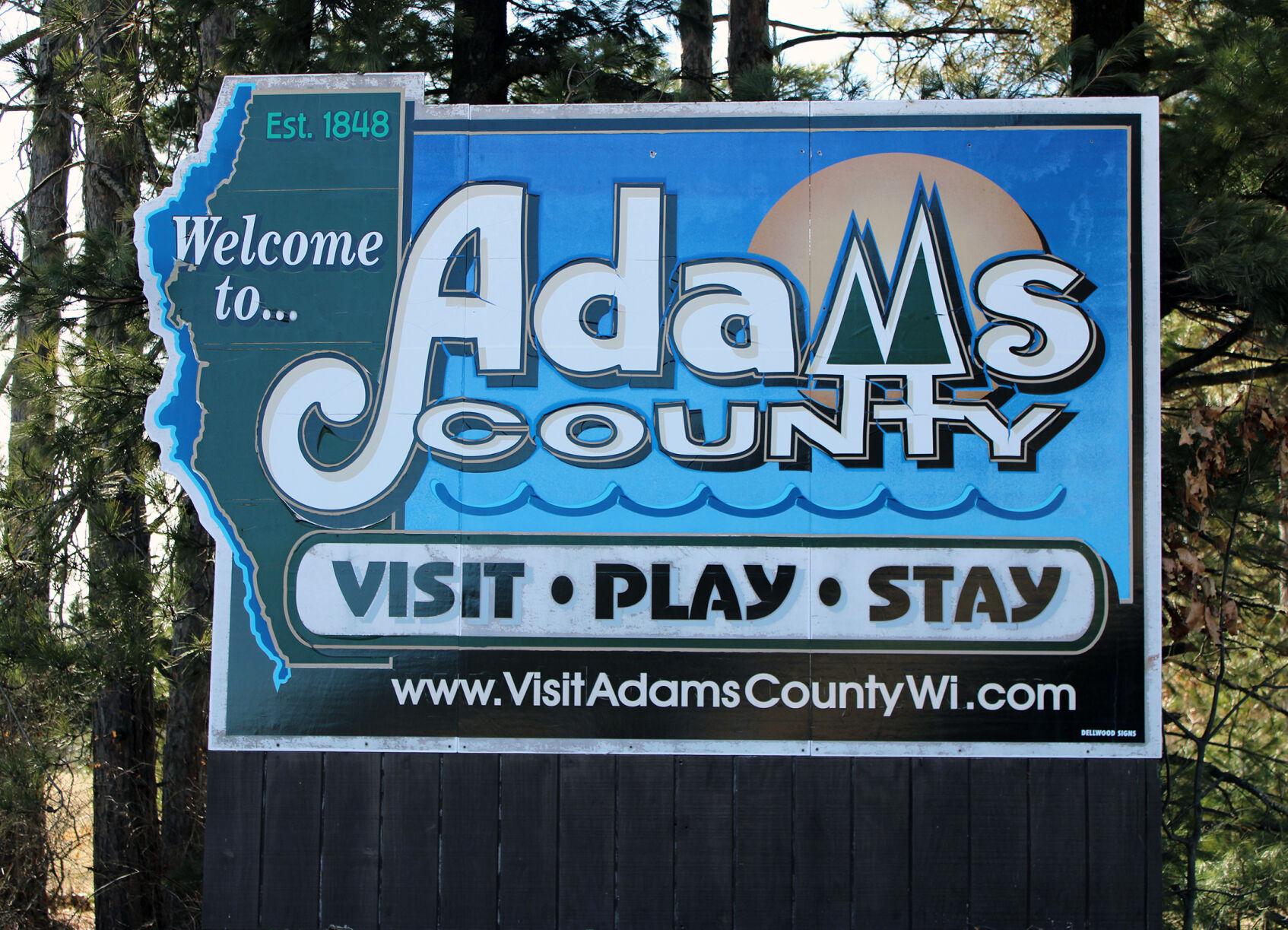 A welcome sign for Adams County that says Visit Play Stay.