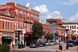 A streetscape in La Crosse County. Red brick buildings line the street, and cars are parked.