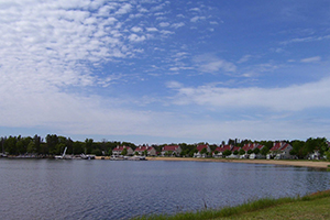 A shoreline in the Town of Germantown. Water is in the foreground, and the shore is in hte background. Blue sky is above.