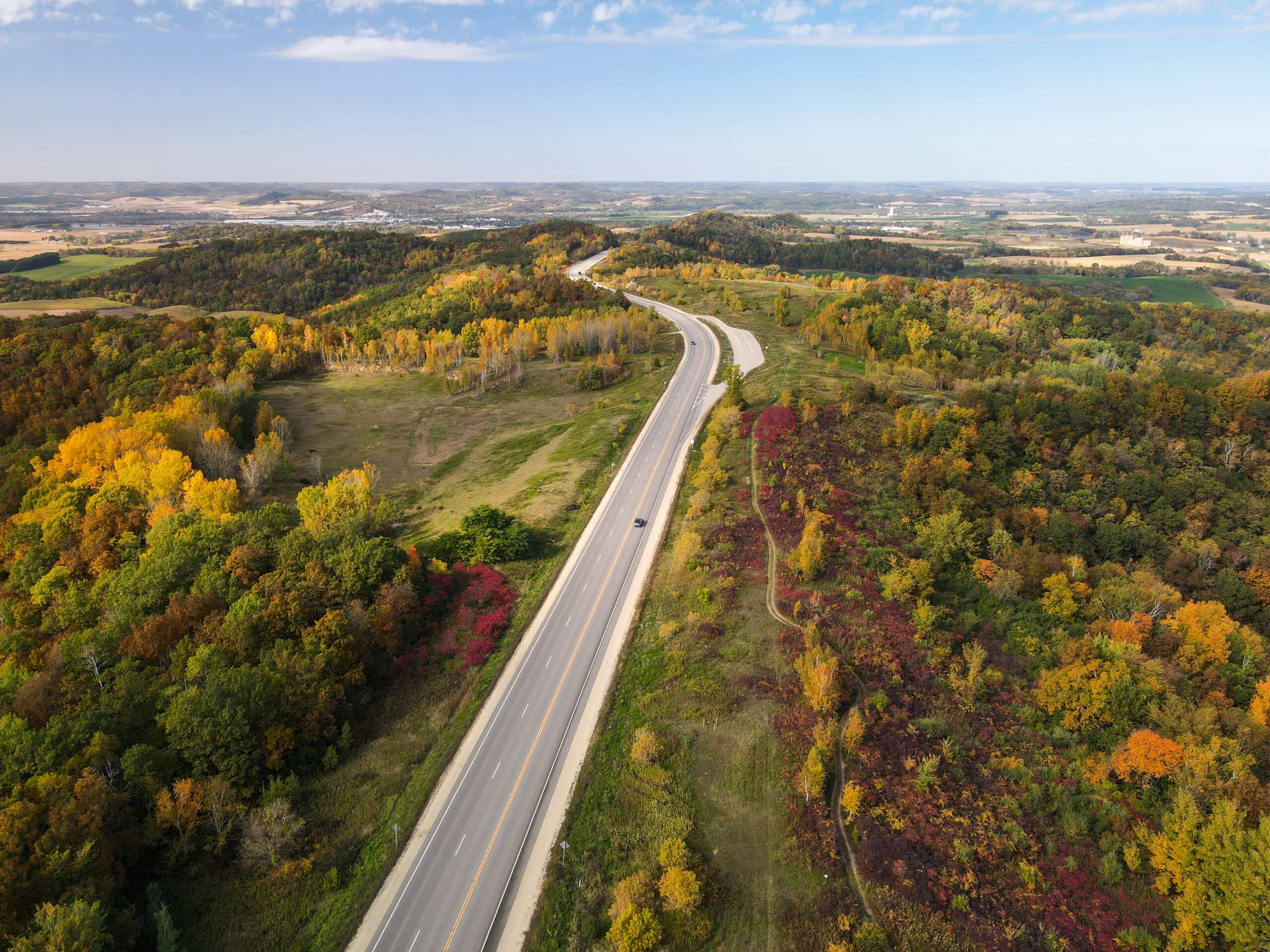 Highway 93 winds through Trempealeau County near Arcadia. Fields of grass and trees line either side of the road.
