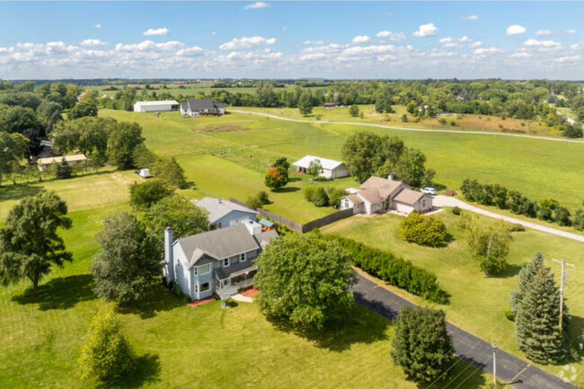 An aerial view of Raymond featuring green grass and houses.